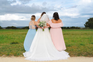 trois femmes en robes à un mariage de dos